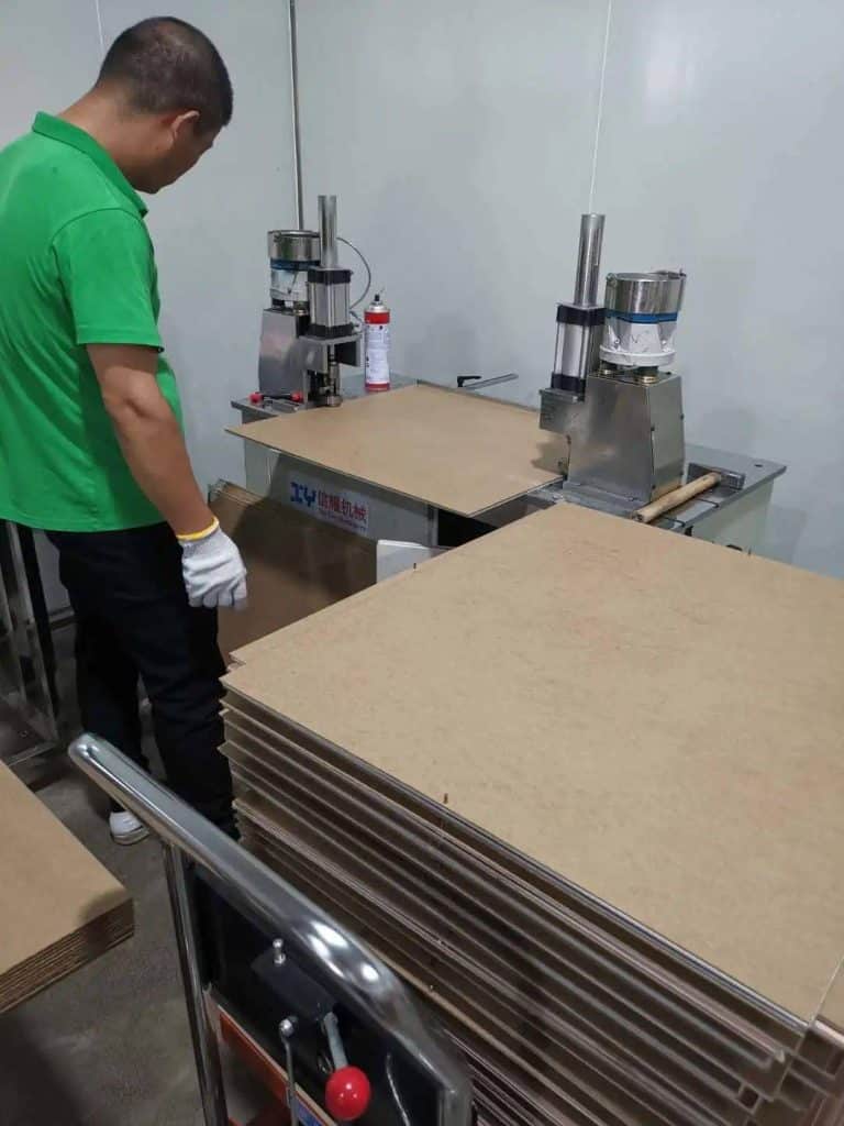 Figure 7. The workers are using a stapler to pin copper-clad laminate and cardboard